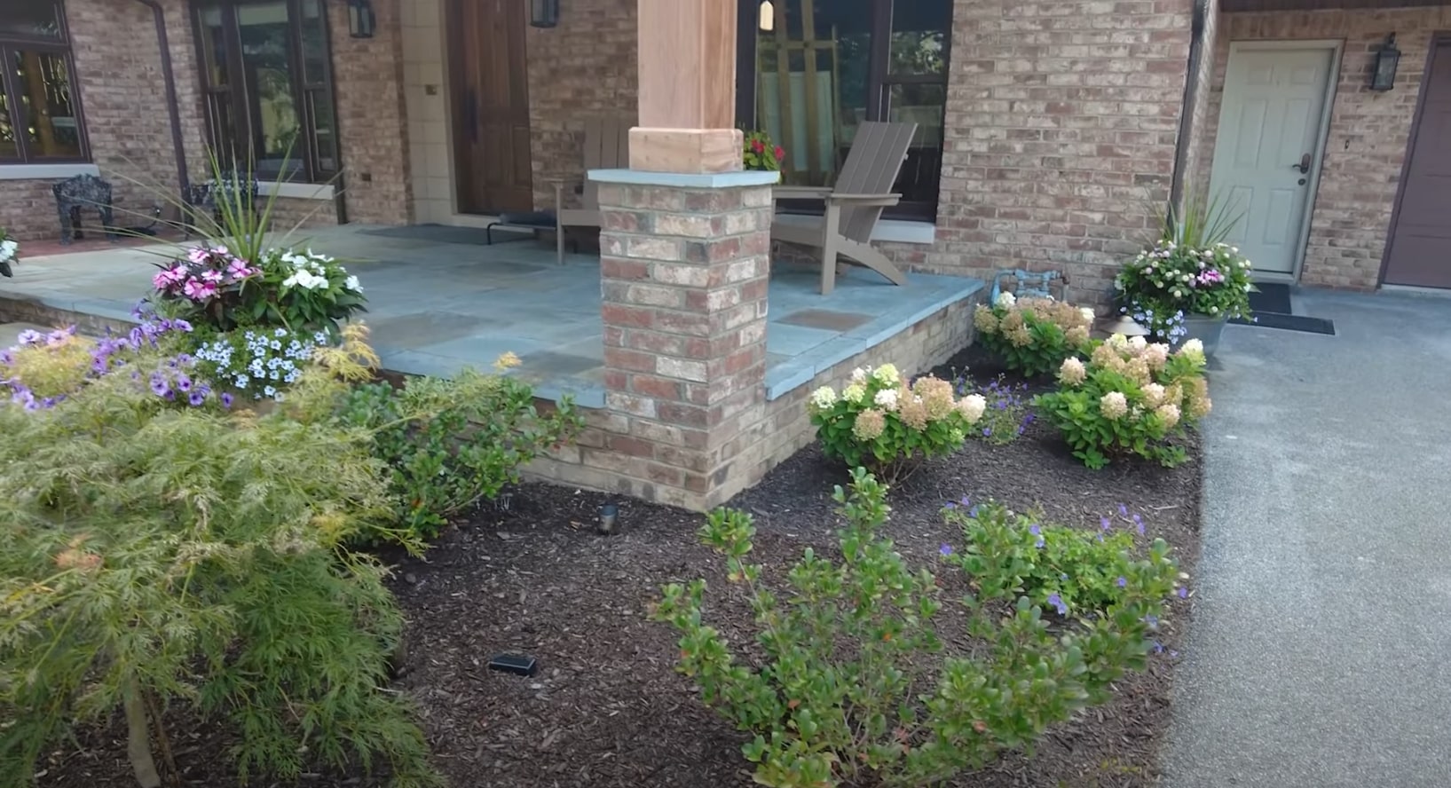 Modern residential outdoor living space with brick columns and professional landscape design