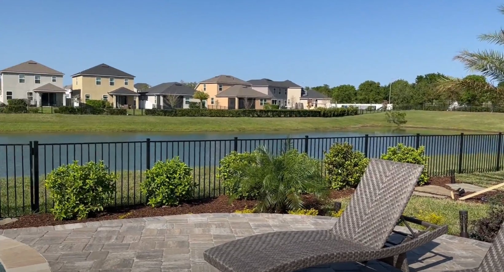 Waterfront residential landscaping with paver patio and privacy plantings